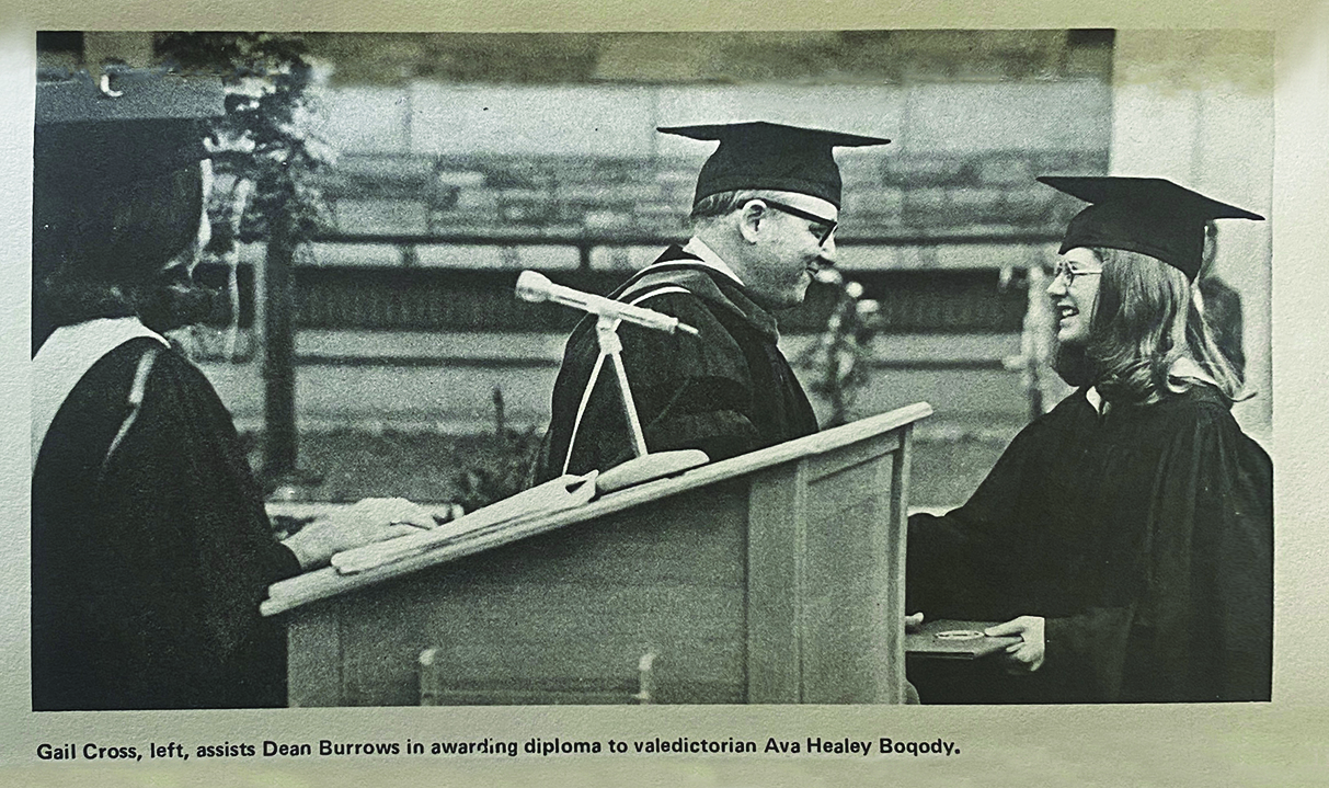 valedictorian accepts diploma from dean during college graduation