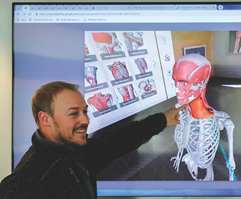 Student pointing at on-screen skeleton in the Immersive Learning Suite