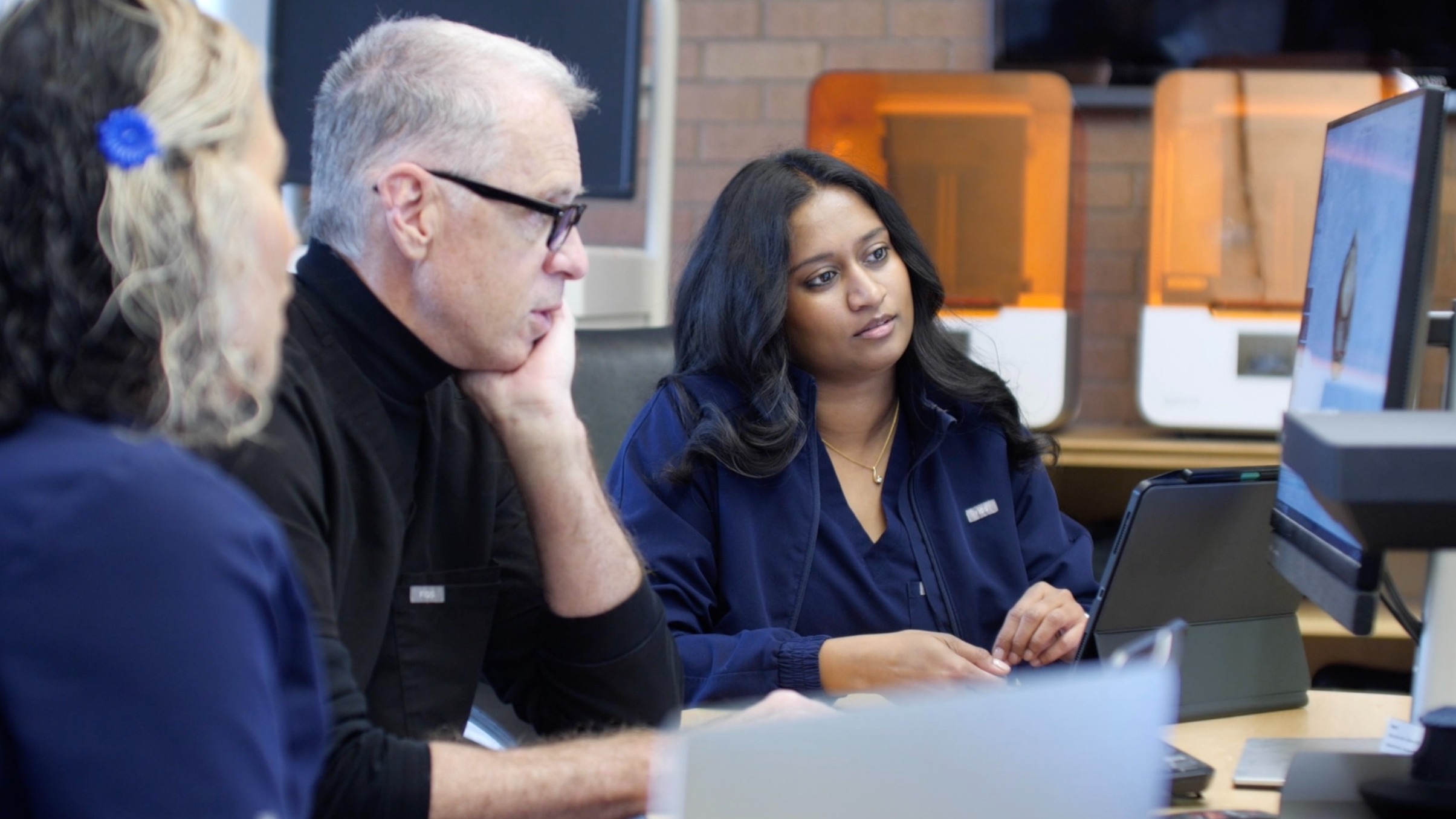 faculty and students working at a computer