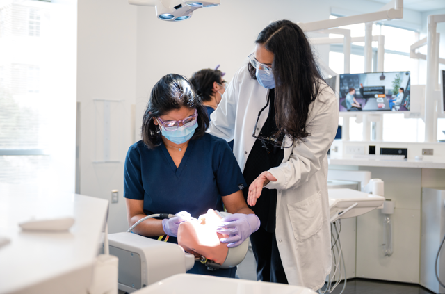 student and faculty in dental simulation hub